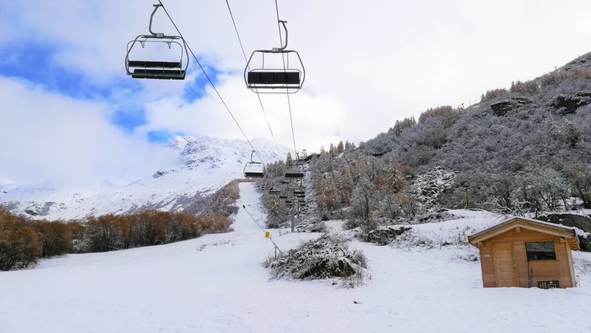 Une piste de ski, un télésiège à l'arrêt, de la neige